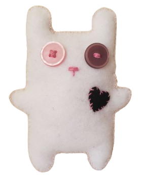 a white felt doll shaped vaguely like a bunny with one pink and one purple button eye, a small pink embroidered nose, a black heart patch, and pale pink blanket stitching around the edges of the body.