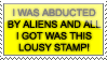 a yellow and black stamp that reads 'i was abducted my aliens and all i got was this lousy stamp!
