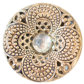 a gold antique button with a four-petal shape and a white gem middle